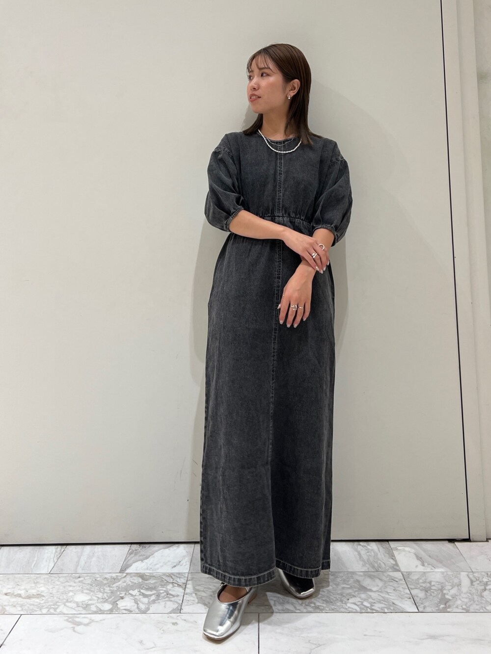 ブラック系のワンピース、シルバー系のパンプス、ブラック系のキャミソールを着用したレディースの夏コーディネートの3枚目の写真