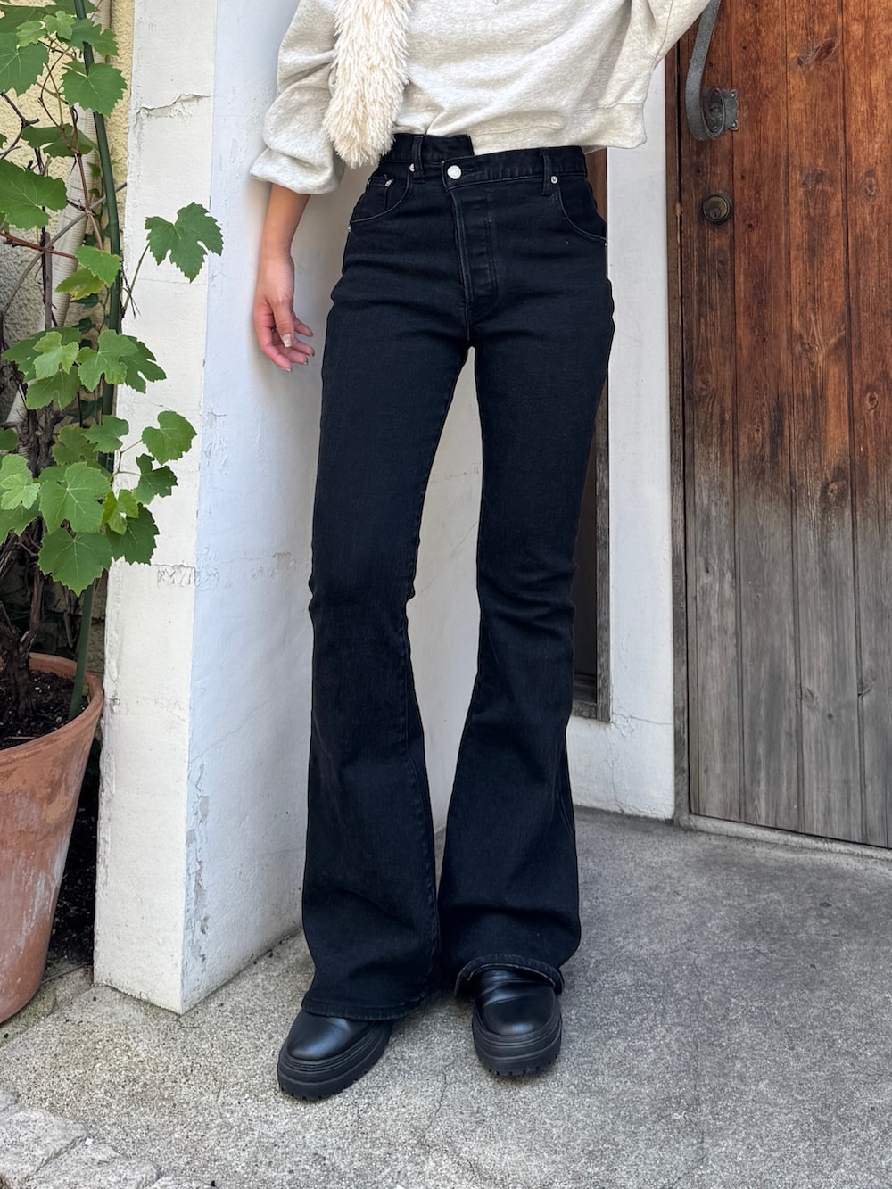 ブラック系のデニムパンツ、グレー系のスウェット、ホワイト系のハンドバッグを着用したレディースの夏コーディネートの6枚目の写真