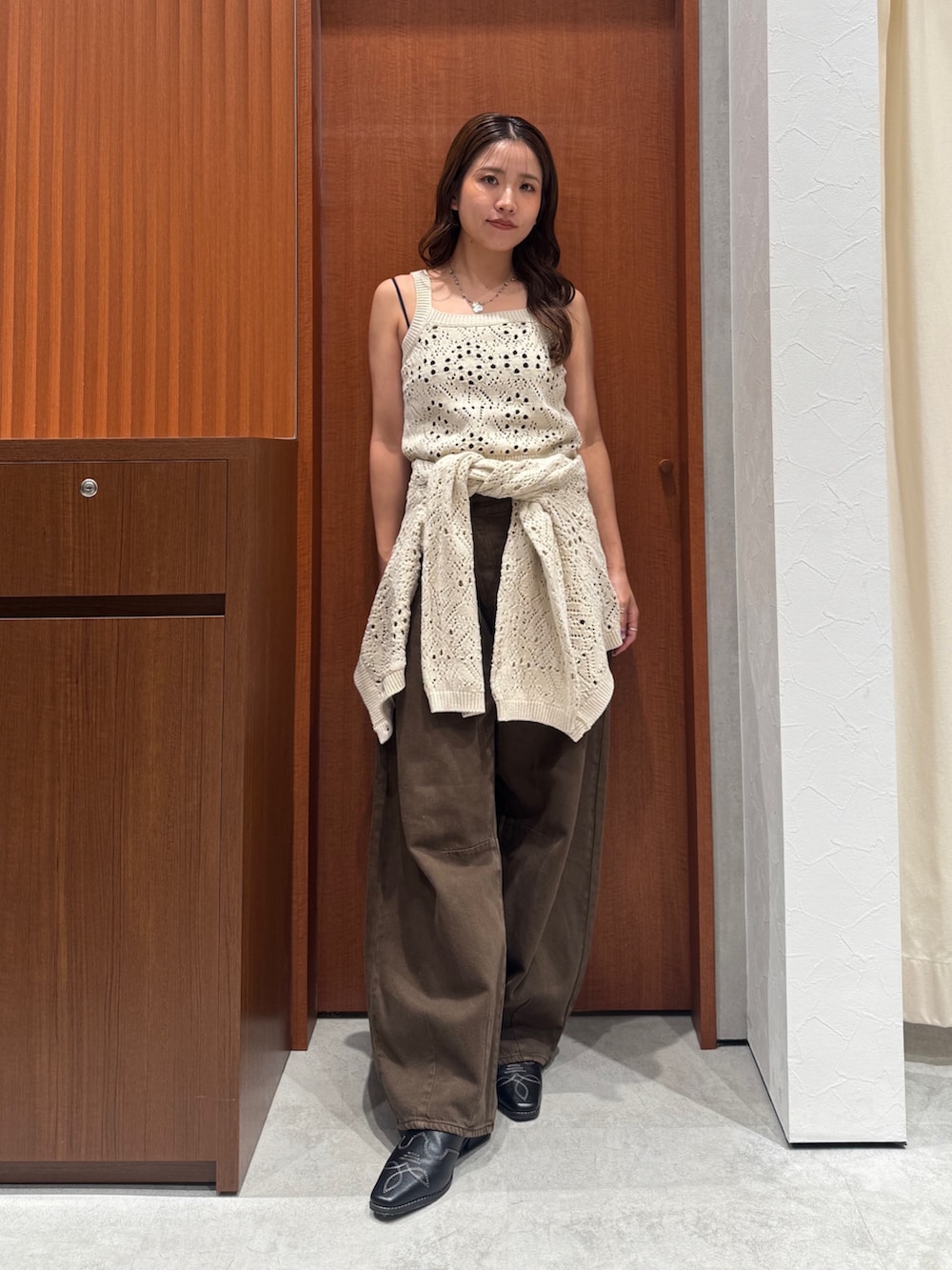 ブラウン系のデニムパンツ、ホワイト系のアンサンブル、ブラック系のその他シューズを着用したレディースの秋コーディネートの5枚目の写真
