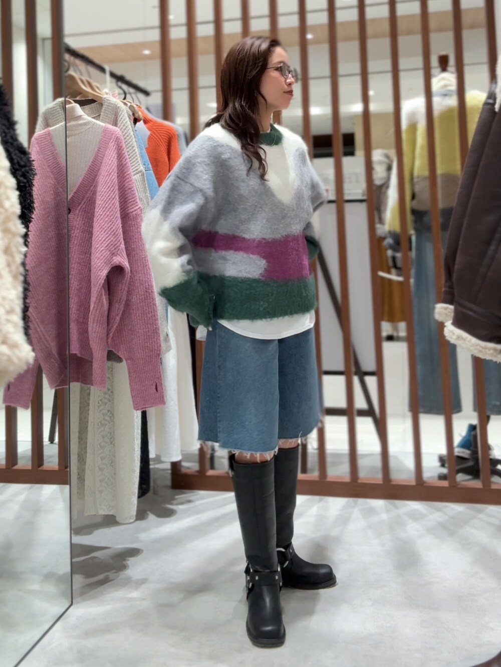 グリーン系のニット/セーター、ホワイト系のTシャツ/カットソー、ブルー系のデニムパンツを着用したレディースの秋コーディネートの9枚目の写真