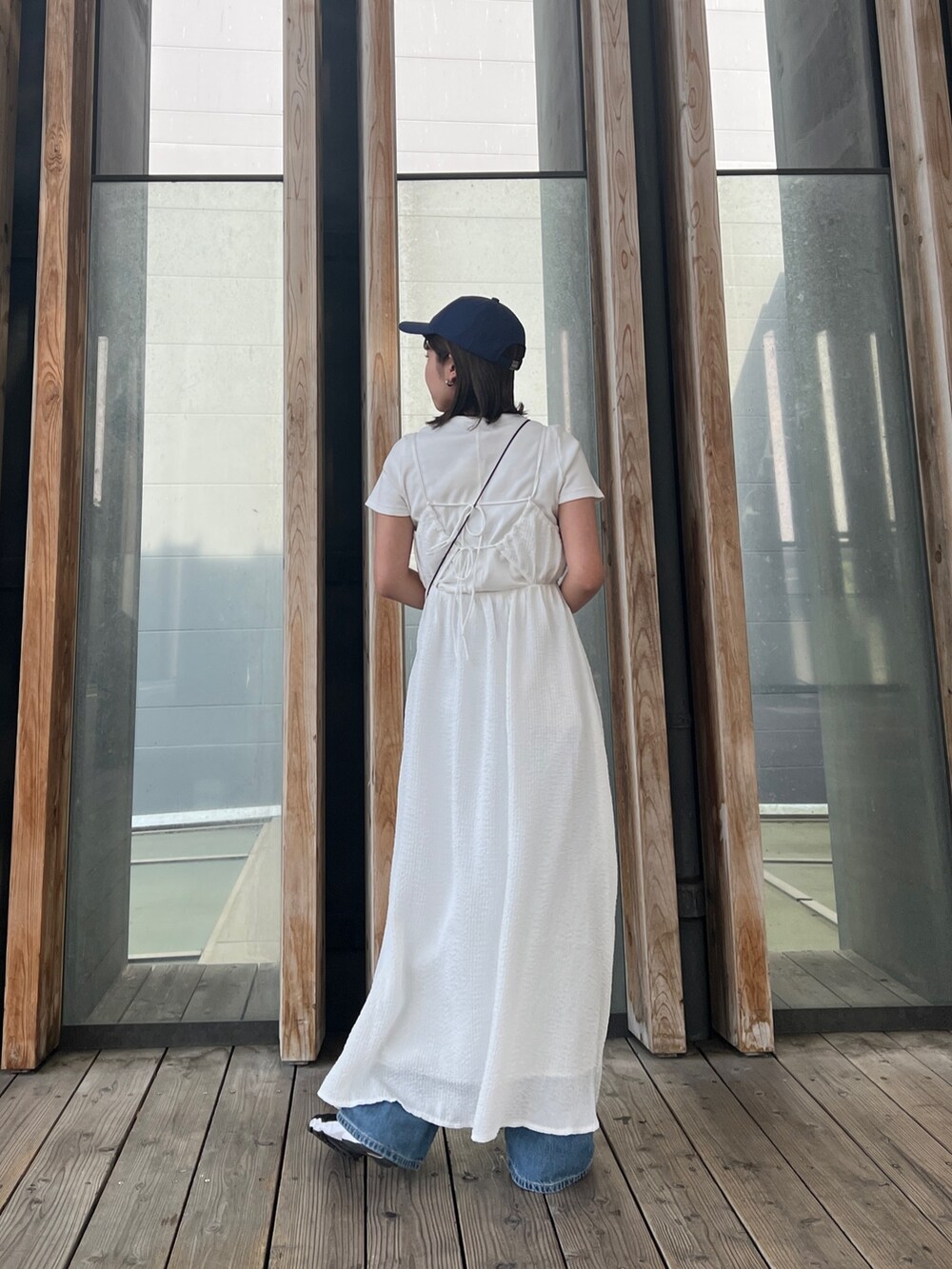 ホワイト系のTシャツ/カットソー、ホワイト系のワンピース、ブルー系のデニムパンツを着用したレディースの春コーディネートの2枚目の写真