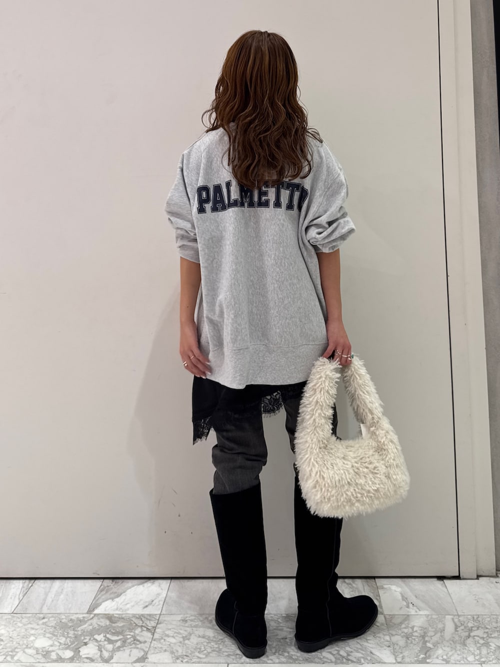 グレー系のスウェット、ブラック系のキャミソール、ブラック系のデニムパンツを着用したレディースの冬コーディネートの5枚目の写真