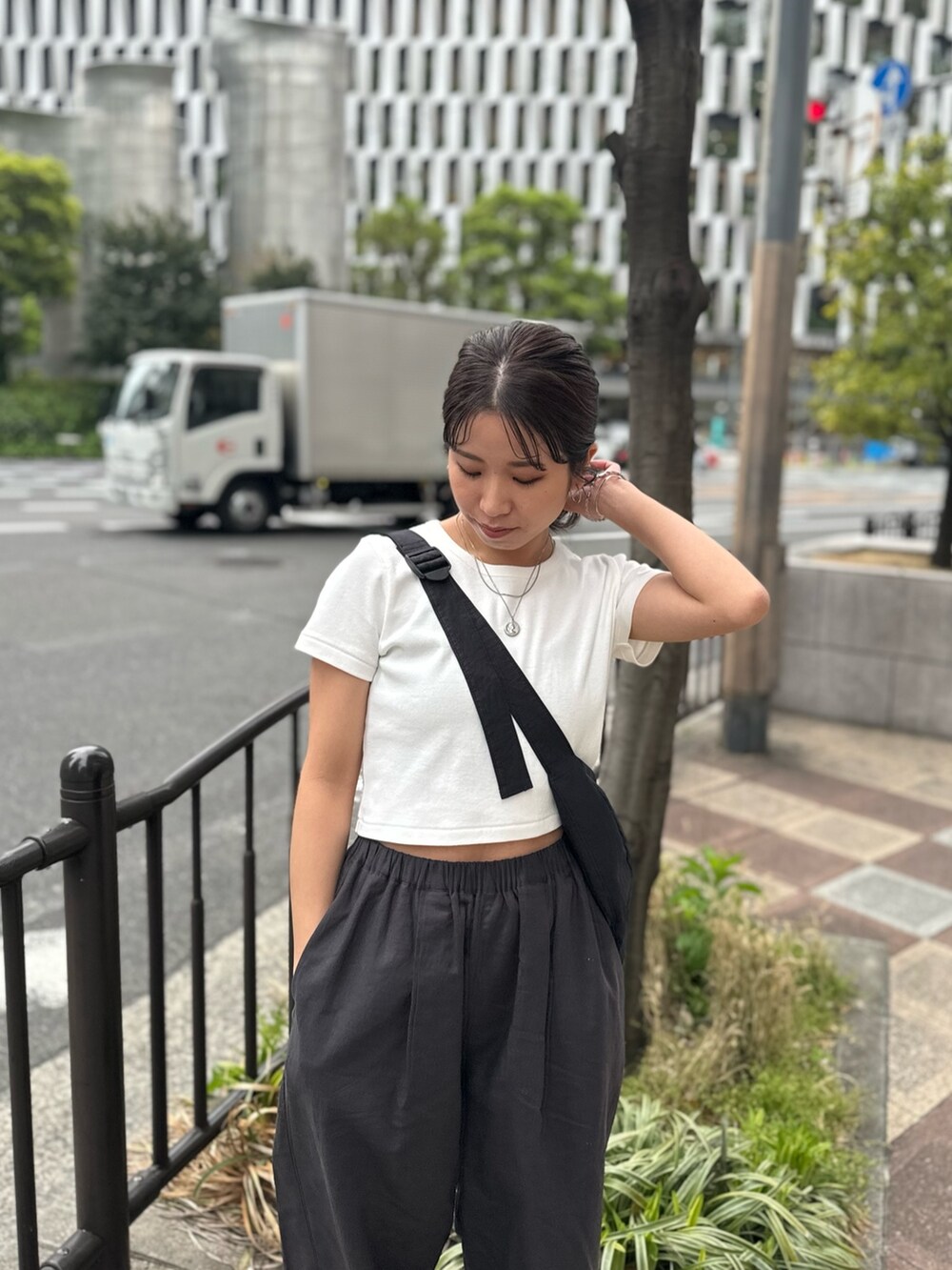 ホワイト系のTシャツ/カットソー、グレー系のその他パンツ、ブラック系のサンダルを着用したレディースの春コーディネートの7枚目の写真