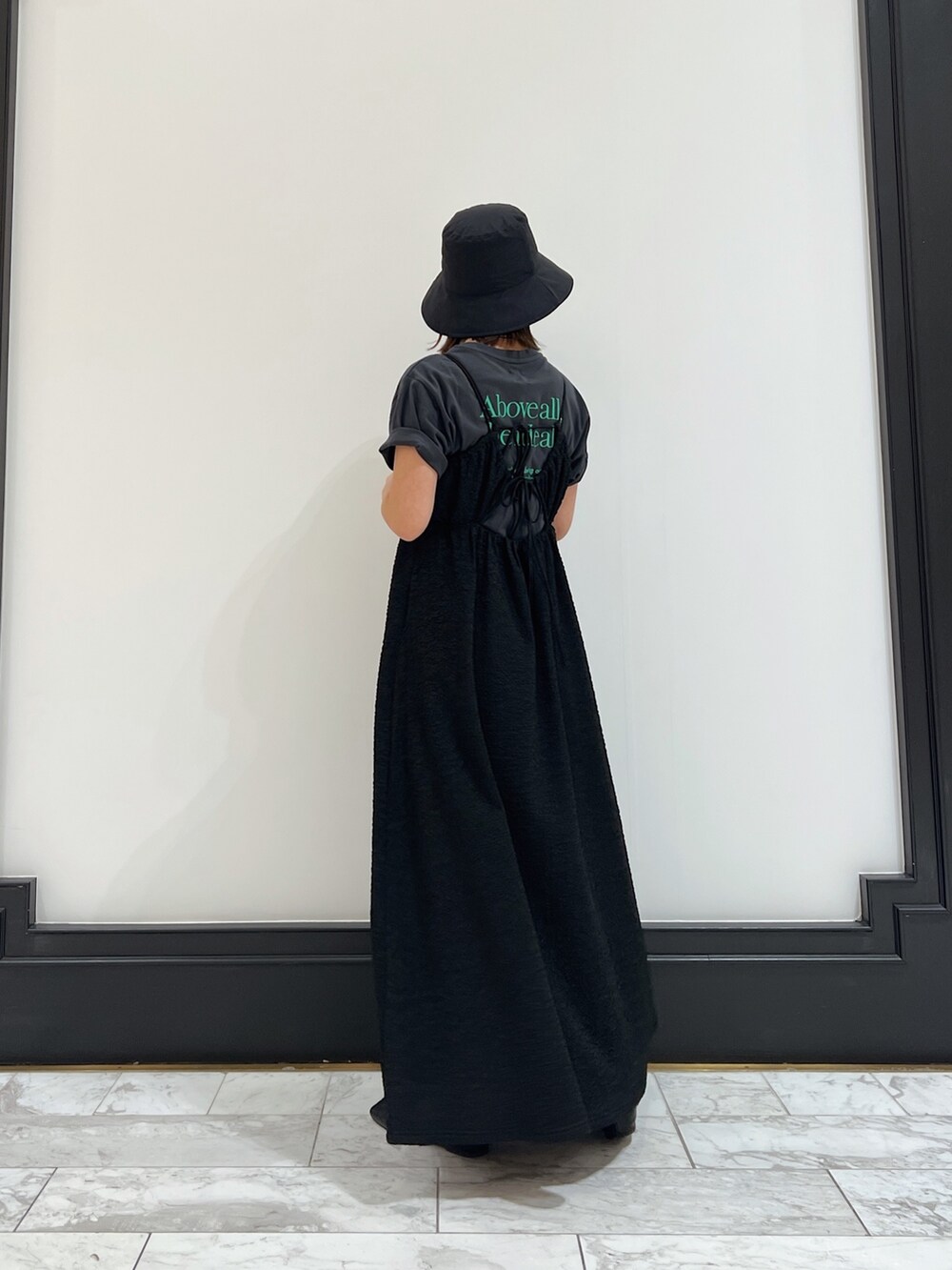 ブラック系のワンピース、グレー系のTシャツ/カットソー、ブラック系のパンプスを着用したレディースの春コーディネートの4枚目の写真