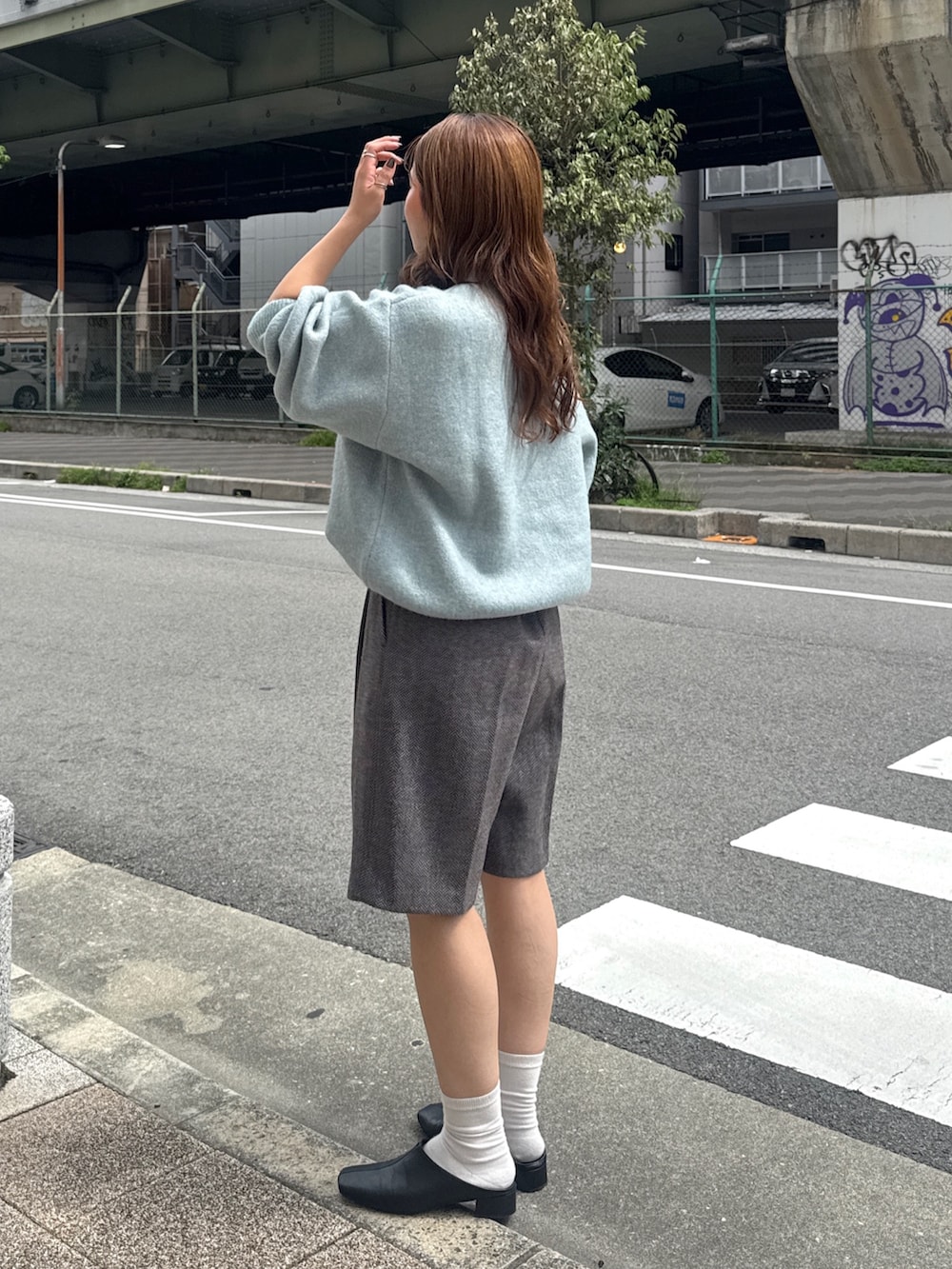 グレー系のその他パンツ、ブラック系のサンダル、グリーン系のニット/セーターを着用したレディースの秋コーディネートの5枚目の写真