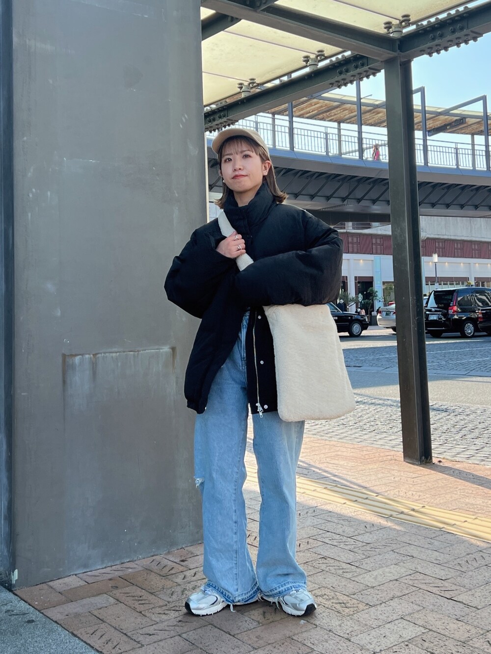 ブラック系のダウンジャケット/コート、ホワイト系のショルダーバッグ、ブルー系のデニムパンツを着用したレディースの秋コーディネートの3枚目の写真