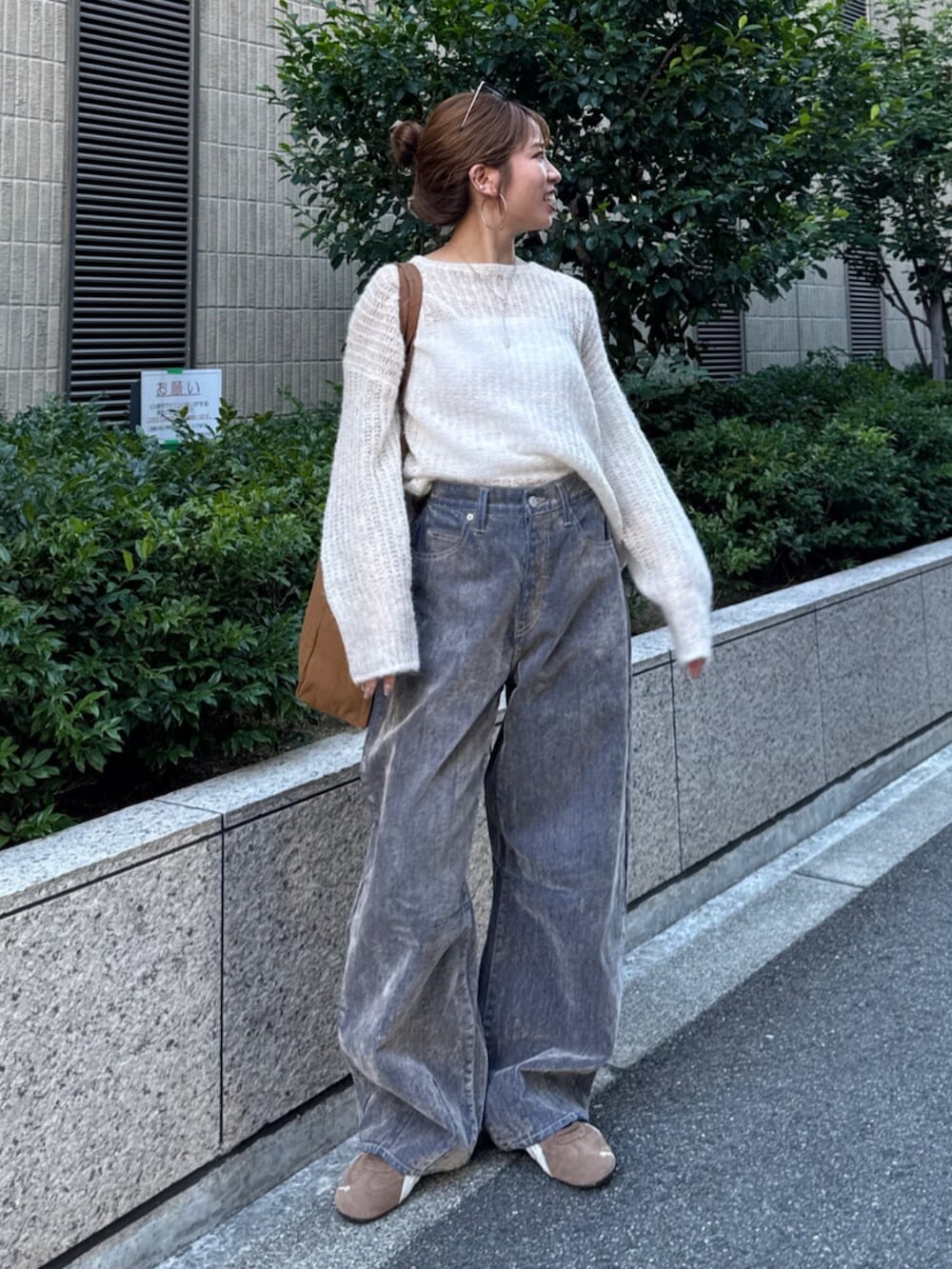 ベージュ系のデニムパンツ、ホワイト系のニット/セーター、ブラウン系のトートバッグを着用したレディースの夏コーディネートの2枚目の写真