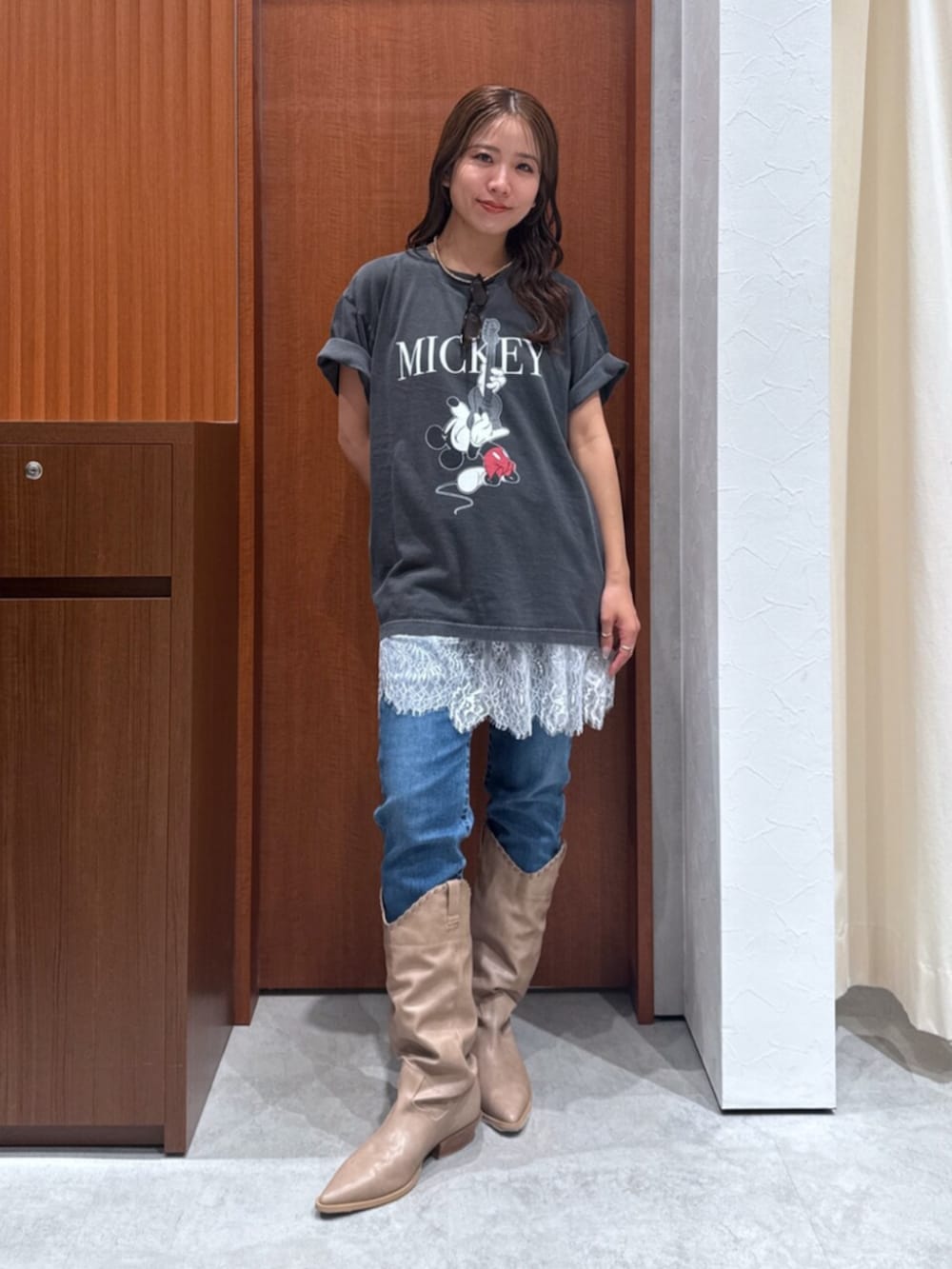 ベージュ系のブーツ、ブルー系のデニムパンツ、ホワイト系のキャミソールを着用したレディースの夏コーディネートの6枚目の写真