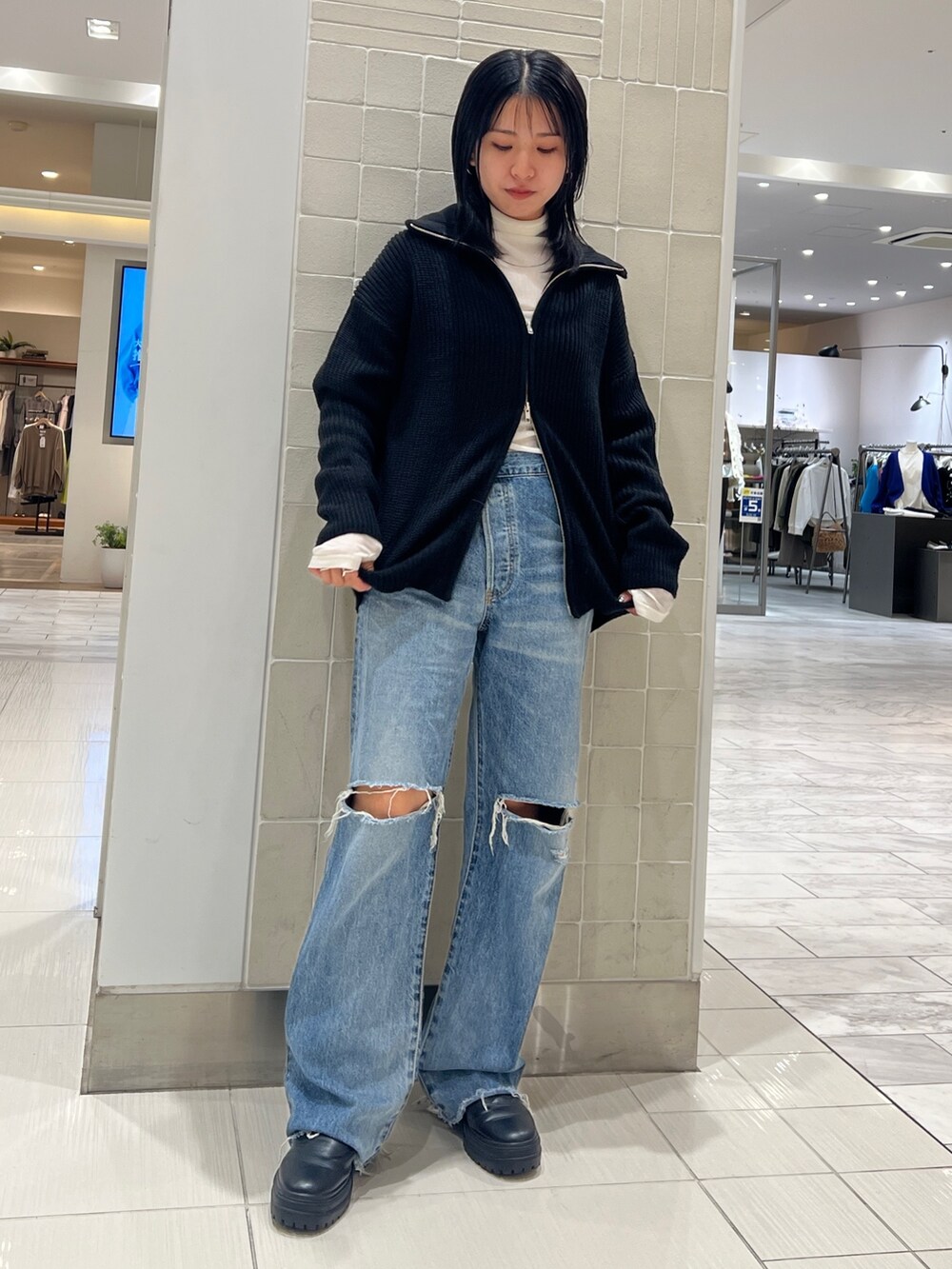 ブルー系のデニムパンツ、ブラック系のカーディガン/ボレロ、ホワイト系のTシャツ/カットソーを着用したレディースの秋コーディネートの3枚目の写真