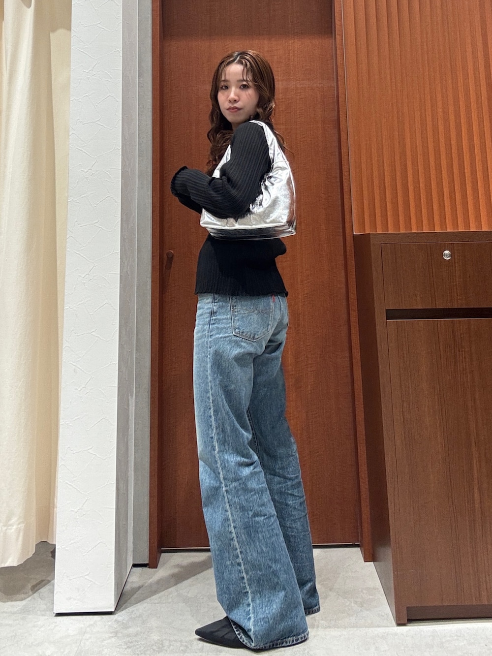 ブルー系のデニムパンツ、ブラック系のカーディガン/ボレロ、ブラック系のパンプスを着用したレディースの春コーディネートの5枚目の写真