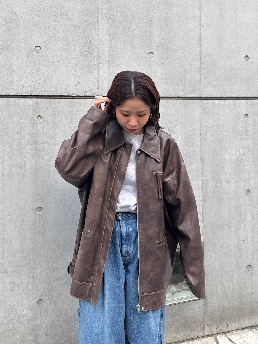 ブルー系のデニムパンツ、グレー系のスウェット、ブラウン系のブルゾンを着用したレディースの秋コーディネートの8枚目の写真