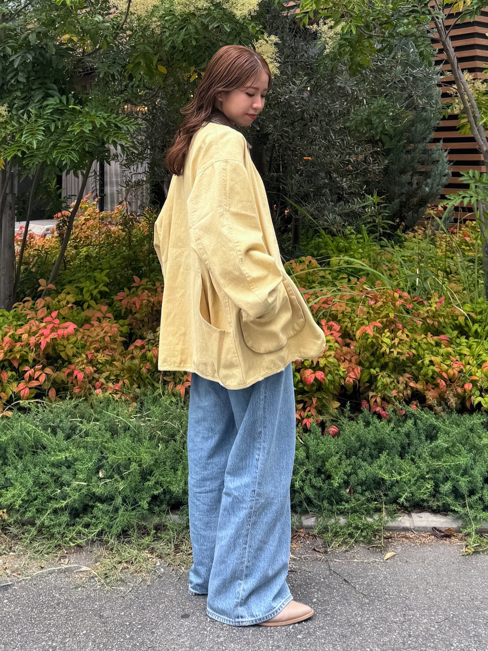 ブルー系のデニムパンツ、イエロー系のブルゾン、ホワイト系のTシャツ/カットソーを着用したレディースの夏コーディネートの3枚目の写真
