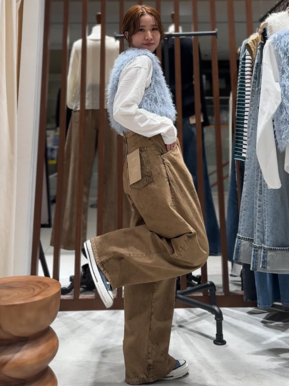 ブラウン系のデニムパンツ、ブルー系のニット/セーター、ホワイト系のTシャツ/カットソーを着用したレディースの春コーディネートの3枚目の写真