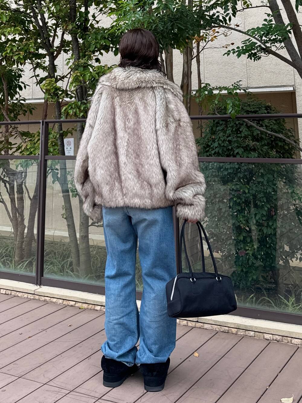 ベージュ系のその他アウター、ブルー系のデニムパンツ、ブラック系のハンドバッグを着用したレディースの秋コーディネートの4枚目の写真