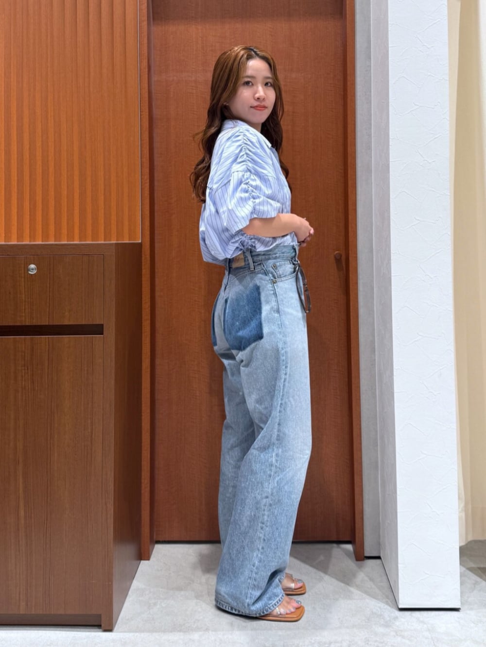 ブルー系のデニムパンツ、ブルー系のシャツ/ブラウス、グレー系のサングラスを着用したレディースの夏コーディネートの2枚目の写真