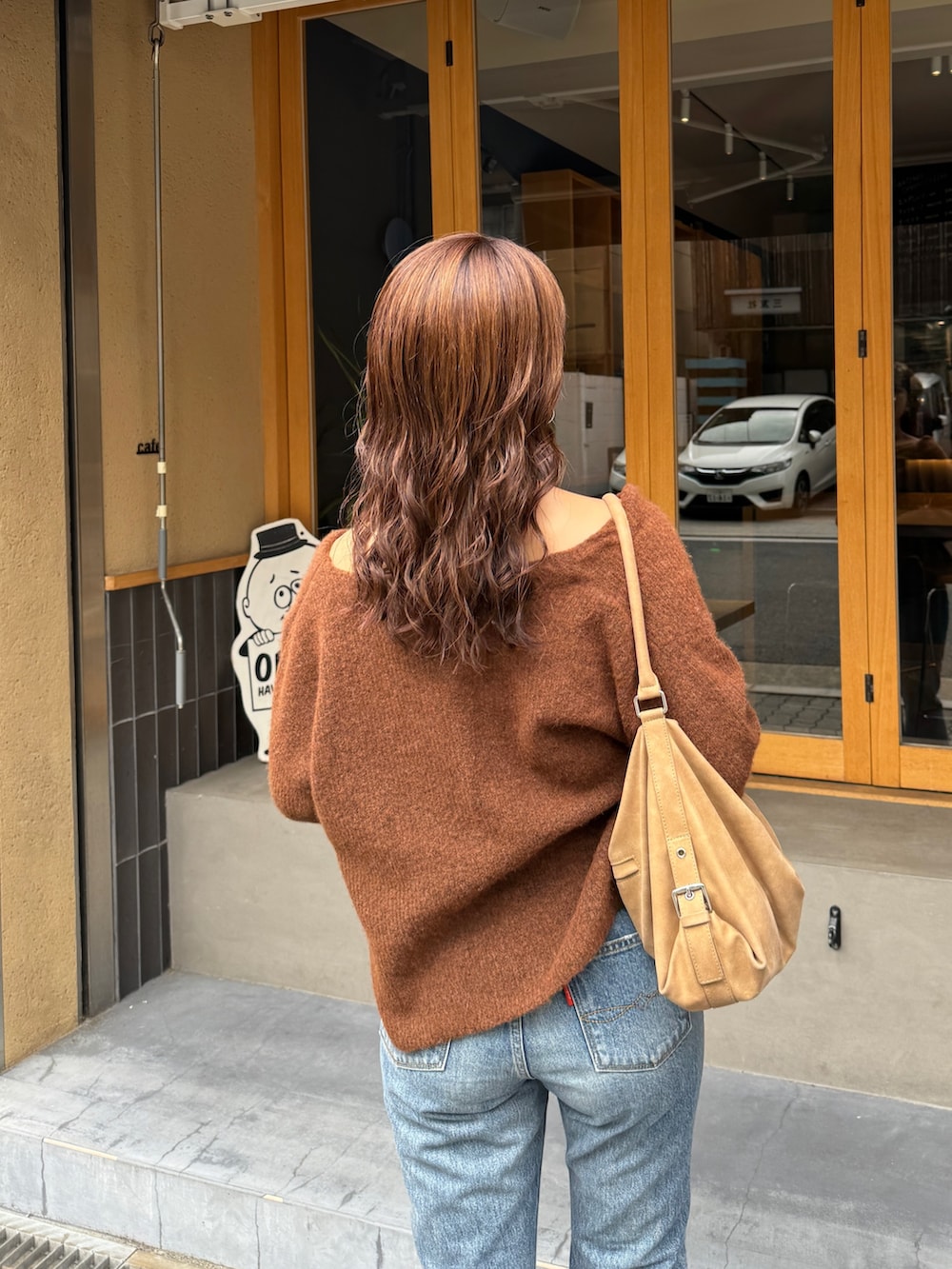 ブルー系のデニムパンツ、ブラウン系のブーツ、ブラウン系のニット/セーターを着用したレディースの秋コーディネートの9枚目の写真