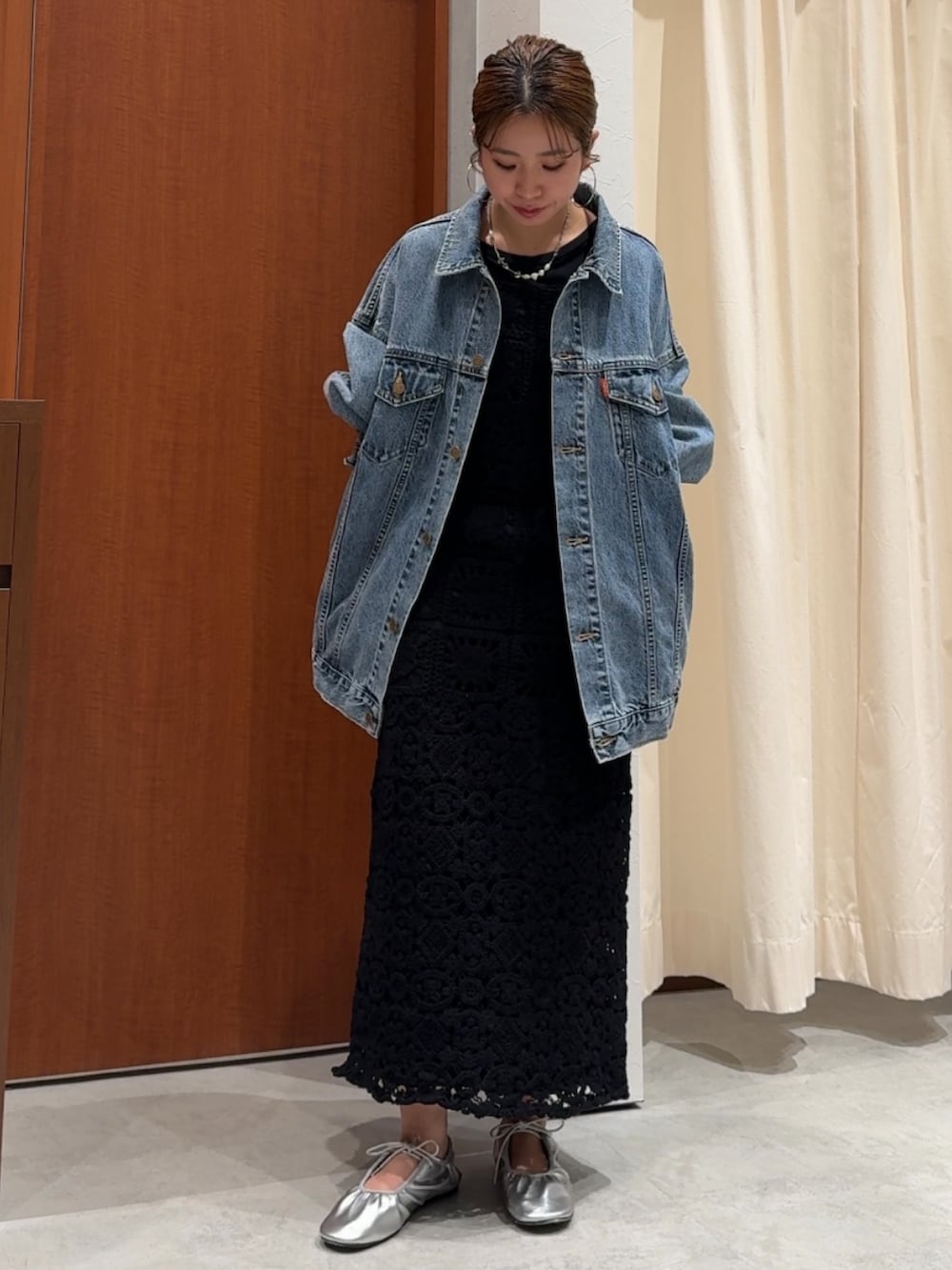 ブラック系のワンピース、ブラック系のTシャツ/カットソー、ブルー系のデニムジャケットを着用したレディースの春コーディネートの2枚目の写真