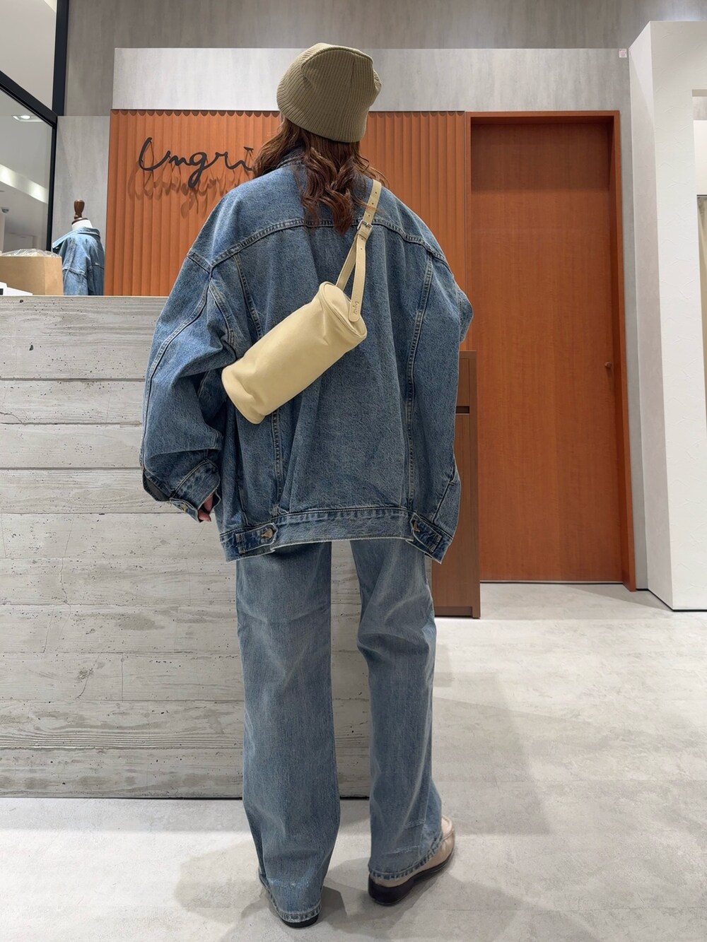 ブルー系のデニムジャケット、ブルー系のデニムパンツ、ホワイト系のタンクトップを着用したレディースの夏コーディネートの4枚目の写真