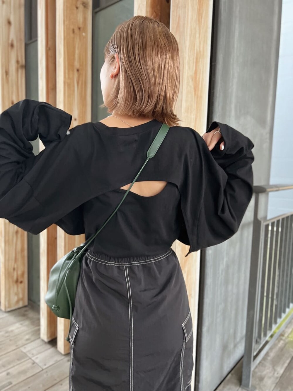 グリーン系のハンドバッグ、ブラック系のTシャツ/カットソー、ブラック系のスカートを着用したレディースの夏コーディネートの5枚目の写真
