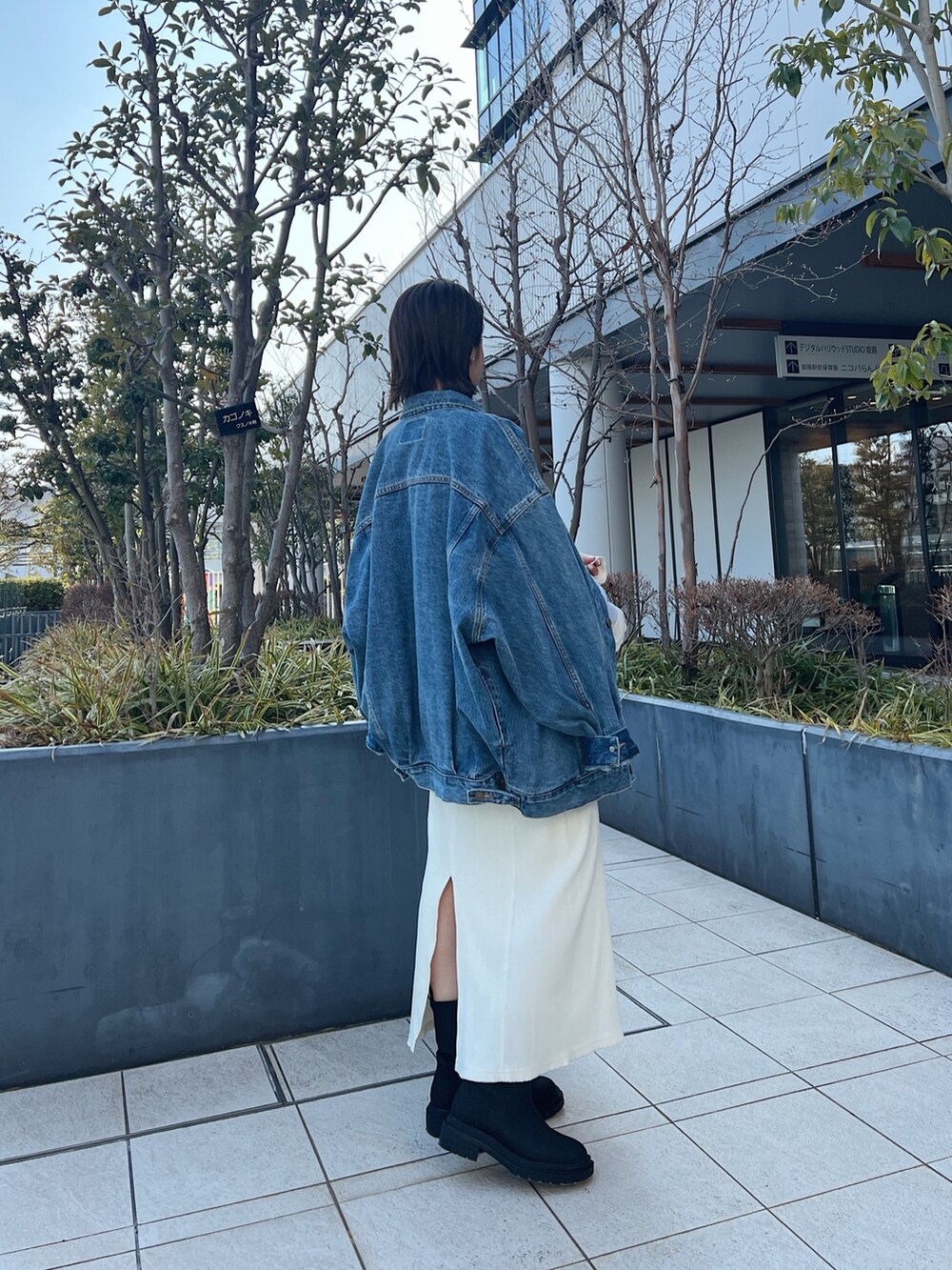 ブルー系のデニムジャケット、グレー系のスウェット、ホワイト系のワンピースを着用したレディースの冬コーディネートの2枚目の写真