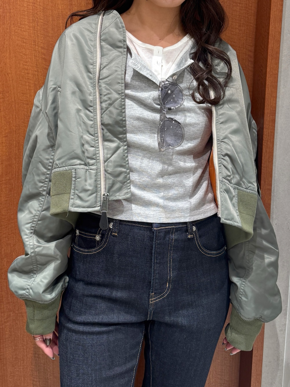 ブルー系のデニムパンツ、グレー系のTシャツ/カットソー、グリーン系のMA-1を着用したレディースの秋コーディネートの7枚目の写真