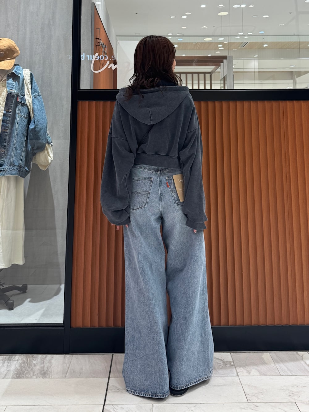 ブルー系のデニムパンツ、グレー系のパーカー、ブラック系のスリッポンを着用したレディースの秋コーディネートの5枚目の写真