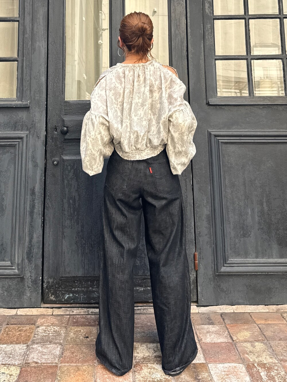 ブラック系のデニムパンツ、ブラック系のスリッポン、ホワイト系のシャツ/ブラウスを着用したレディースの秋コーディネートの5枚目の写真