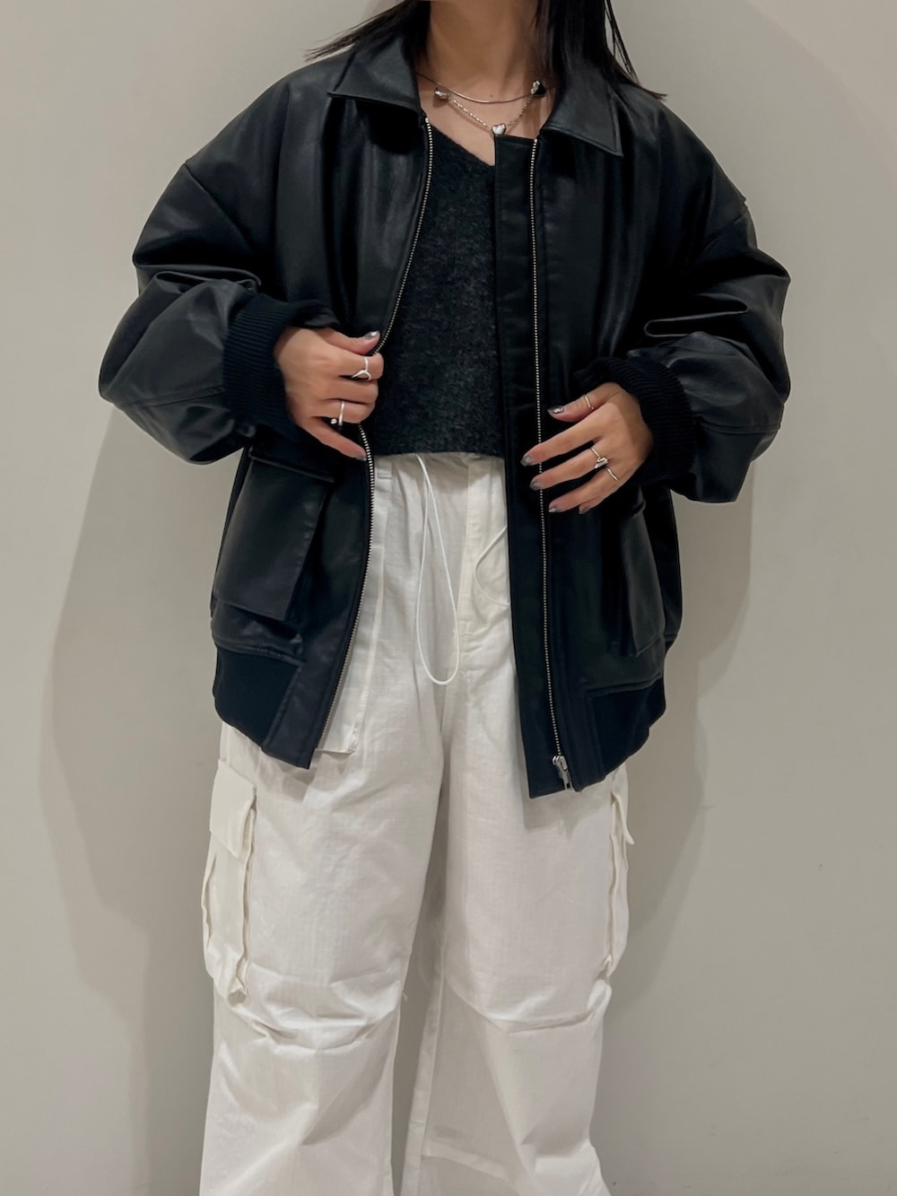 グレー系のニット/セーター、ホワイト系のカーゴパンツ、ブラック系のブルゾンを着用したレディースの秋コーディネートの2枚目の写真