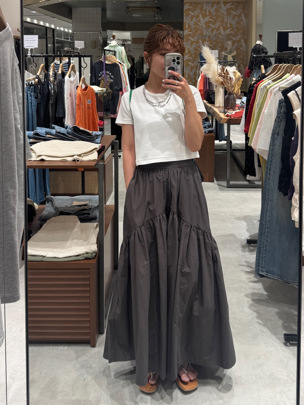 グレー系のスカート、シルバー系のサンダル、ホワイト系のTシャツ/カットソーを着用したレディースの春コーディネートの10枚目の写真