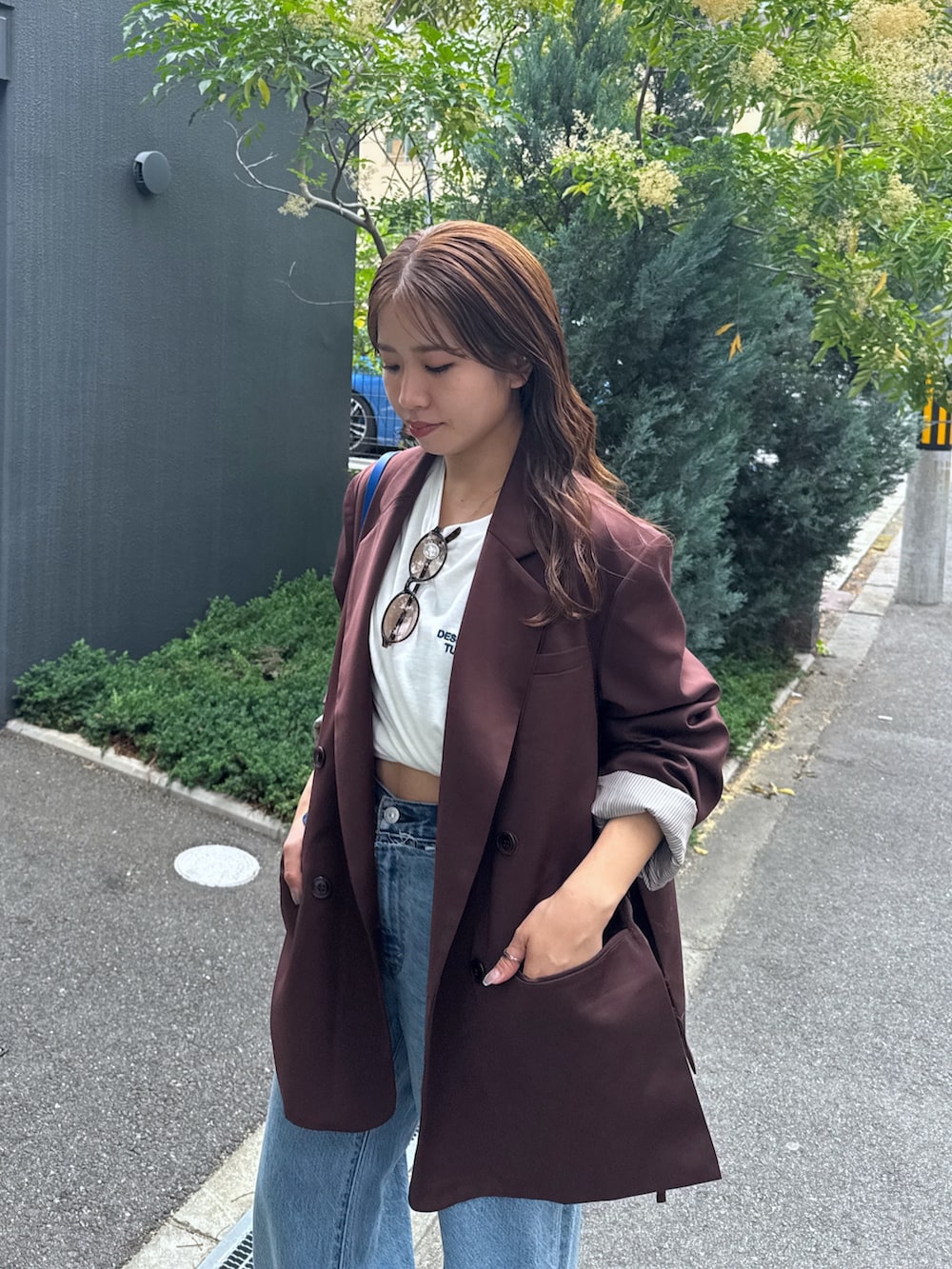 ブルー系のデニムパンツ、ブラウン系のテーラードジャケット、ホワイト系のTシャツ/カットソーを着用したレディースの夏コーディネートの5枚目の写真