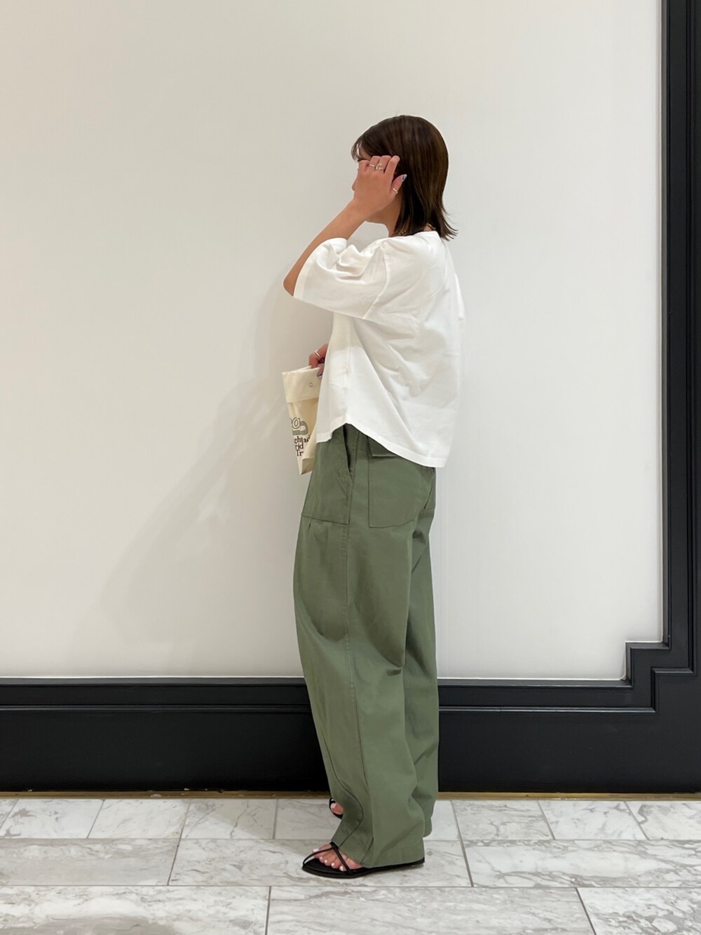 ベージュ系のその他パンツ、ブラック系のサンダル、イエロー系のネックレスを着用したレディースの春コーディネートの3枚目の写真