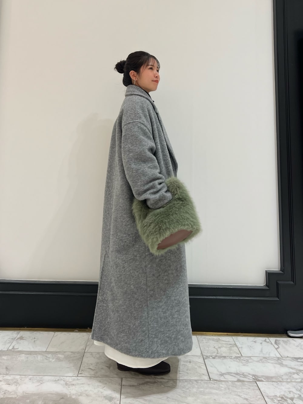 ブラウン系のブーツ、ブラック系のワンピース、グレー系のチェスターコートを着用したレディースの冬コーディネートの2枚目の写真