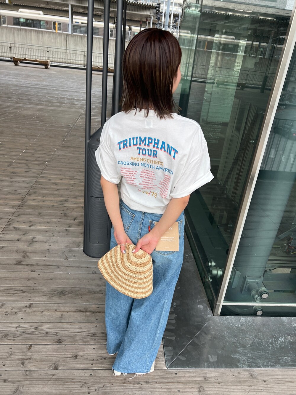 ホワイト系のTシャツ/カットソー、ホワイト系のサンダル、ブルー系のデニムパンツを着用したレディースの春コーディネートの10枚目の写真