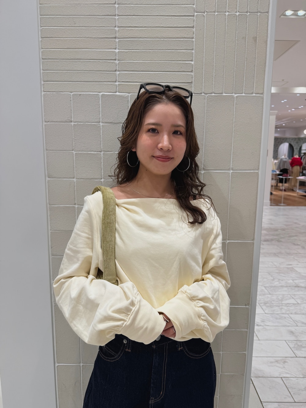 ブルー系のデニムパンツ、ホワイト系のTシャツ/カットソー、グリーン系のハンドバッグを着用したレディースの冬コーディネートの6枚目の写真