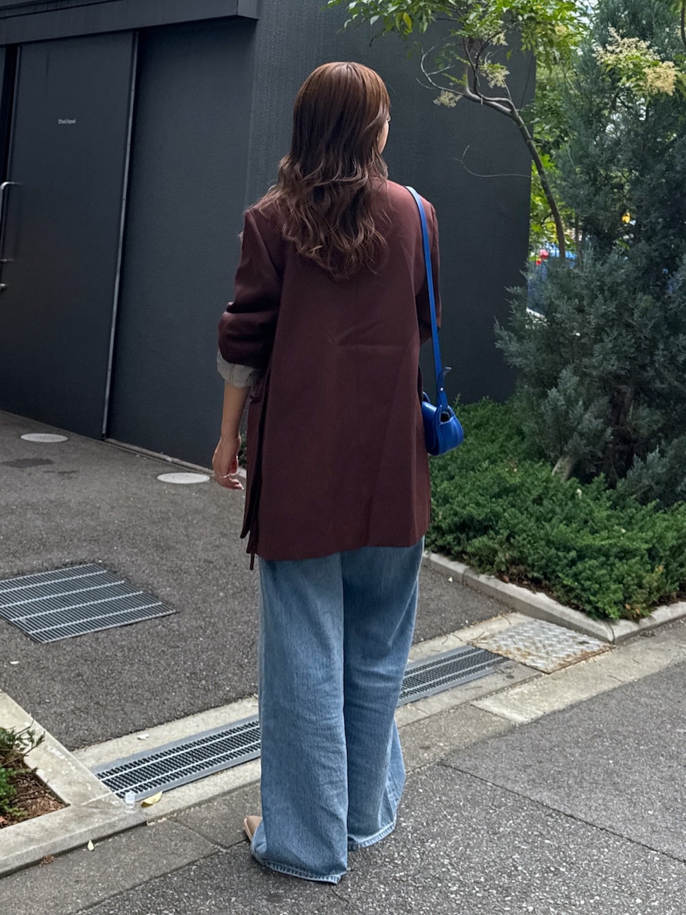 ブルー系のデニムパンツ、ブラウン系のテーラードジャケット、ホワイト系のTシャツ/カットソーを着用したレディースの夏コーディネートの4枚目の写真