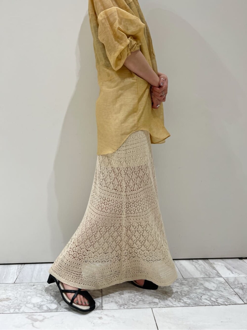 ブラウン系のシャツ/ブラウス、ベージュ系のスカート、ブラック系のサンダルを着用したレディースの春コーディネートの6枚目の写真