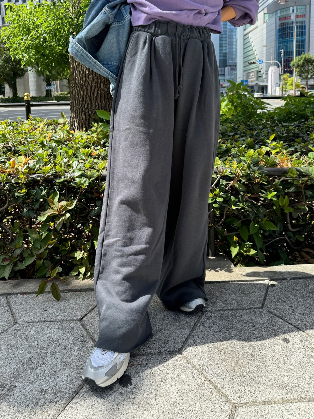 グレー系のスウェットパンツ、ブルー系のデニムジャケット、パープル系のスウェットを着用したレディースの秋コーディネートの9枚目の写真