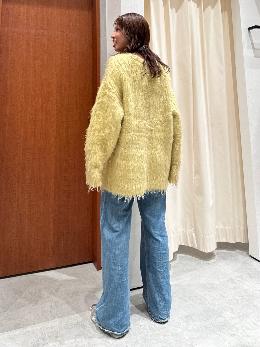 ブルー系のデニムパンツ、イエロー系のカーディガン/ボレロを着用したレディースの秋コーディネートの5枚目の写真