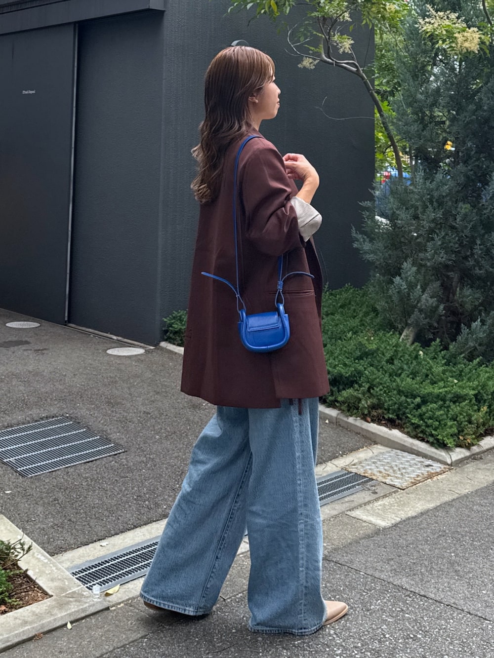 ブルー系のデニムパンツ、ブラウン系のテーラードジャケット、ホワイト系のTシャツ/カットソーを着用したレディースの夏コーディネートの3枚目の写真