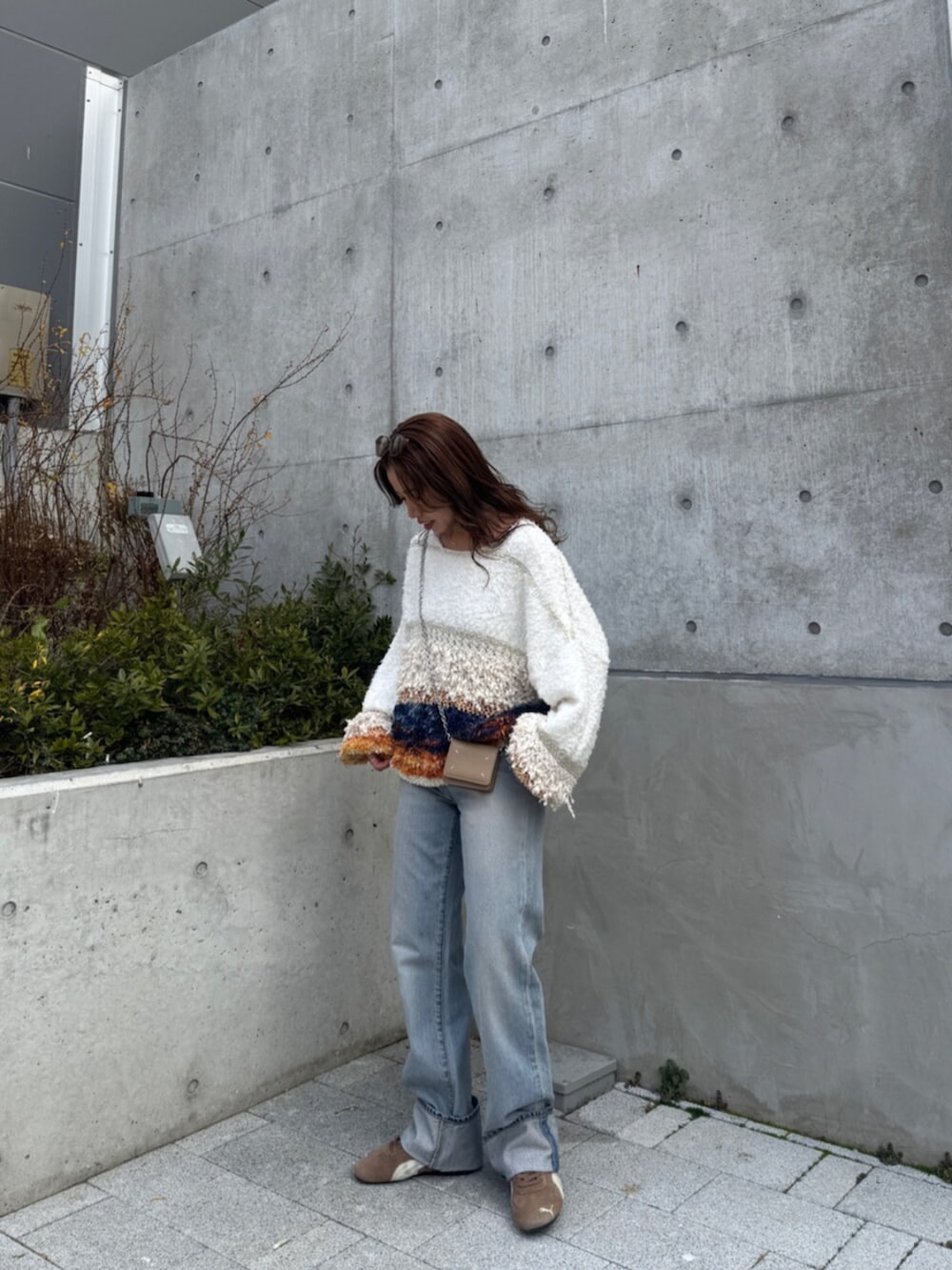 ブルー系のデニムパンツ、ホワイト系のニット/セーター、ブラウン系のスニーカーを着用したレディースの冬コーディネートの5枚目の写真