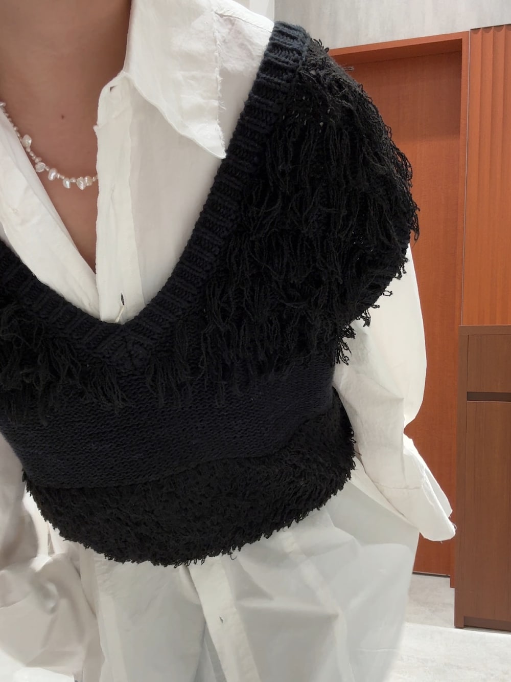 ブラック系のベスト、ホワイト系のシャツ/ブラウス、ブルー系のデニムパンツを着用したレディースの春コーディネートの10枚目の写真