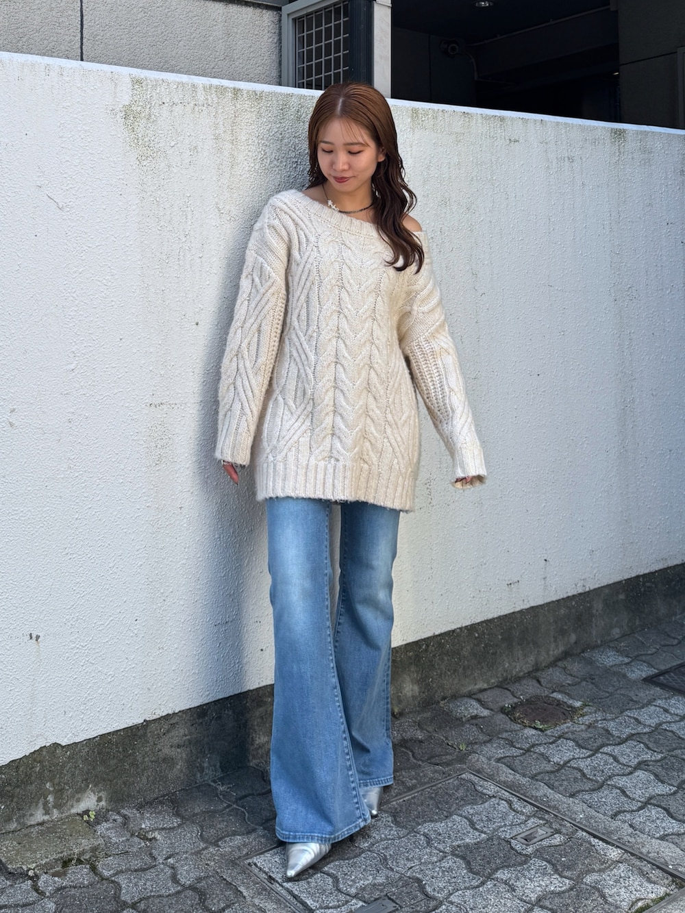 ホワイト系のニット/セーター、ブルー系のデニムパンツ、シルバー系のその他シューズを着用したレディースの夏コーディネートの2枚目の写真