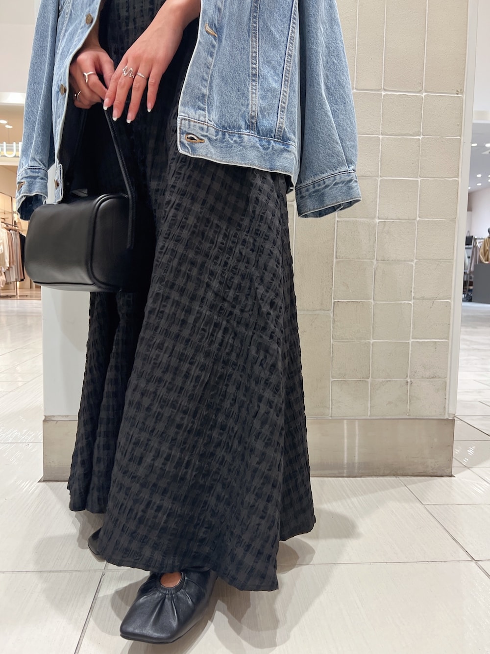 ブラック系のワンピース、グリーン系のタンクトップ、ブルー系のデニムジャケットを着用したレディースの冬コーディネートの10枚目の写真