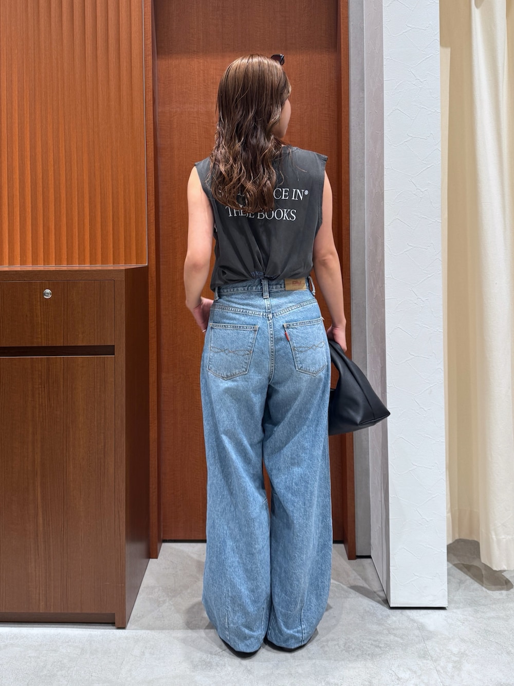 グレー系のタンクトップ、ブルー系のデニムパンツ、その他のサンダルを着用したレディースの夏コーディネートの5枚目の写真