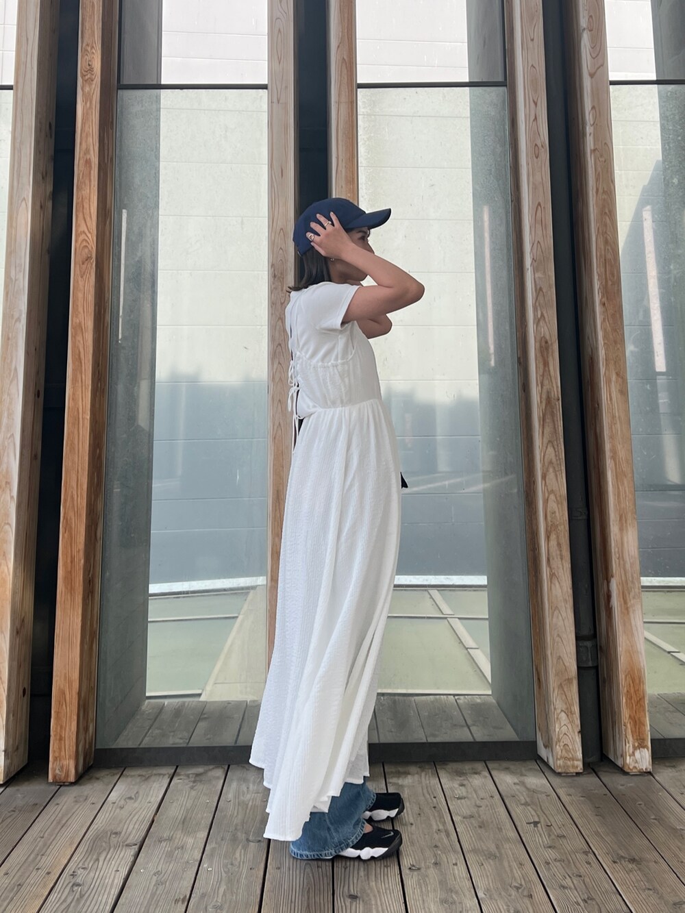 ホワイト系のTシャツ/カットソー、ホワイト系のワンピース、ブルー系のデニムパンツを着用したレディースの春コーディネートの3枚目の写真