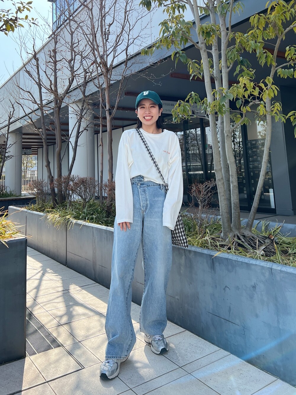 ブルー系のデニムパンツ、ホワイト系のTシャツ/カットソー、グレー系のショルダーバッグを着用したレディースの冬コーディネートの3枚目の写真