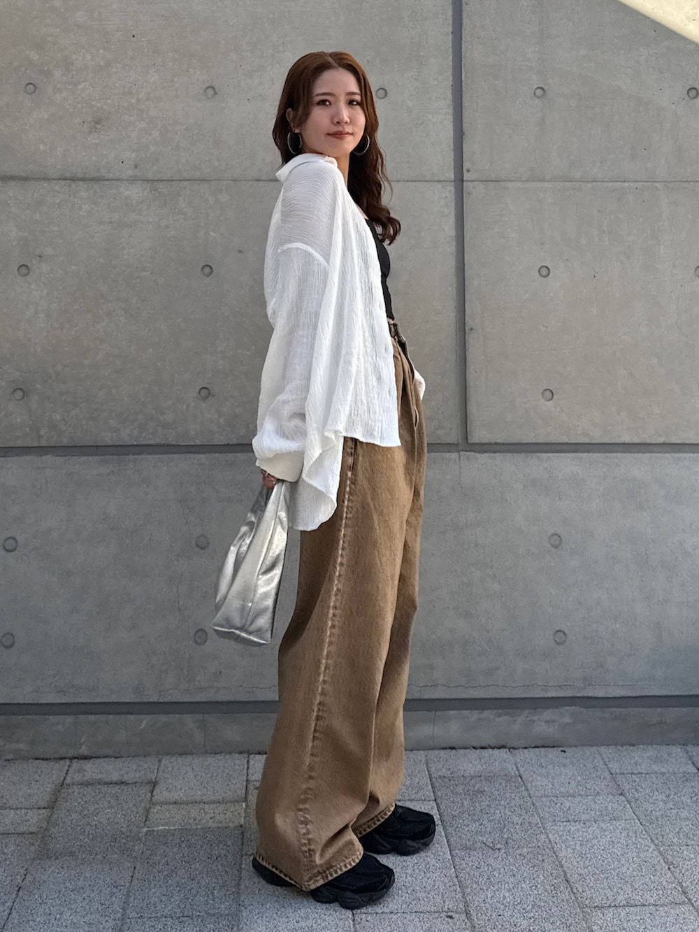 ブラウン系のデニムパンツ、ホワイト系のシャツ/ブラウスを着用したレディースの春コーディネートの5枚目の写真