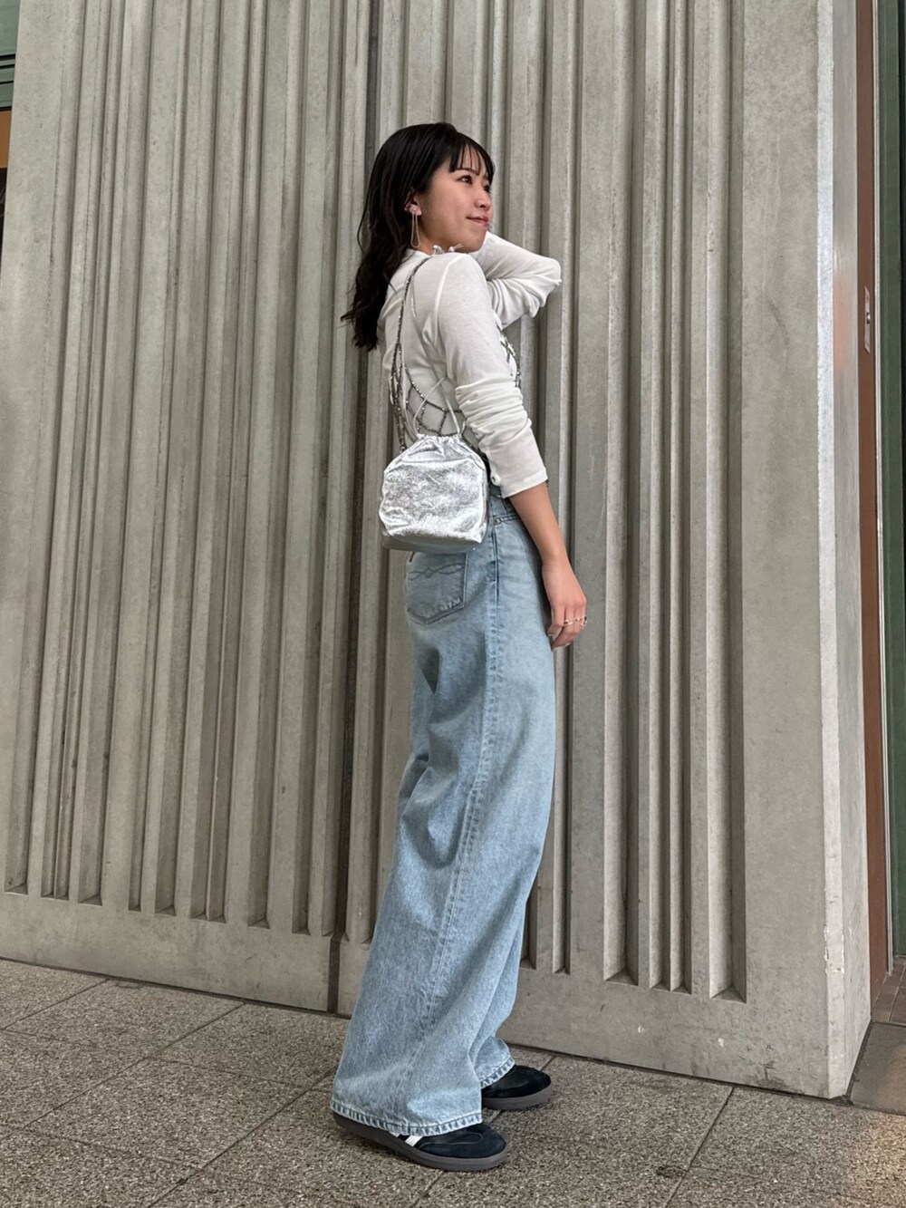 ブラック系のベスト、ブルー系のデニムパンツ、ホワイト系のTシャツ/カットソーを着用したレディースの冬コーディネートの5枚目の写真