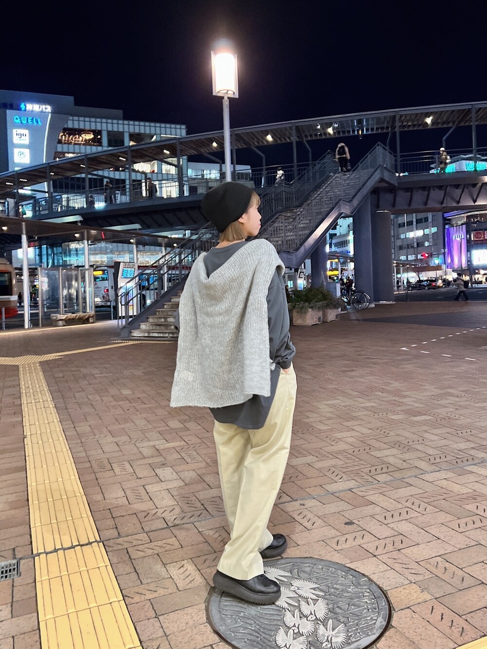 グレー系のTシャツ/カットソー、グレー系のニット/セーター、ベージュ系のスラックスを着用したレディースの冬コーディネートの5枚目の写真