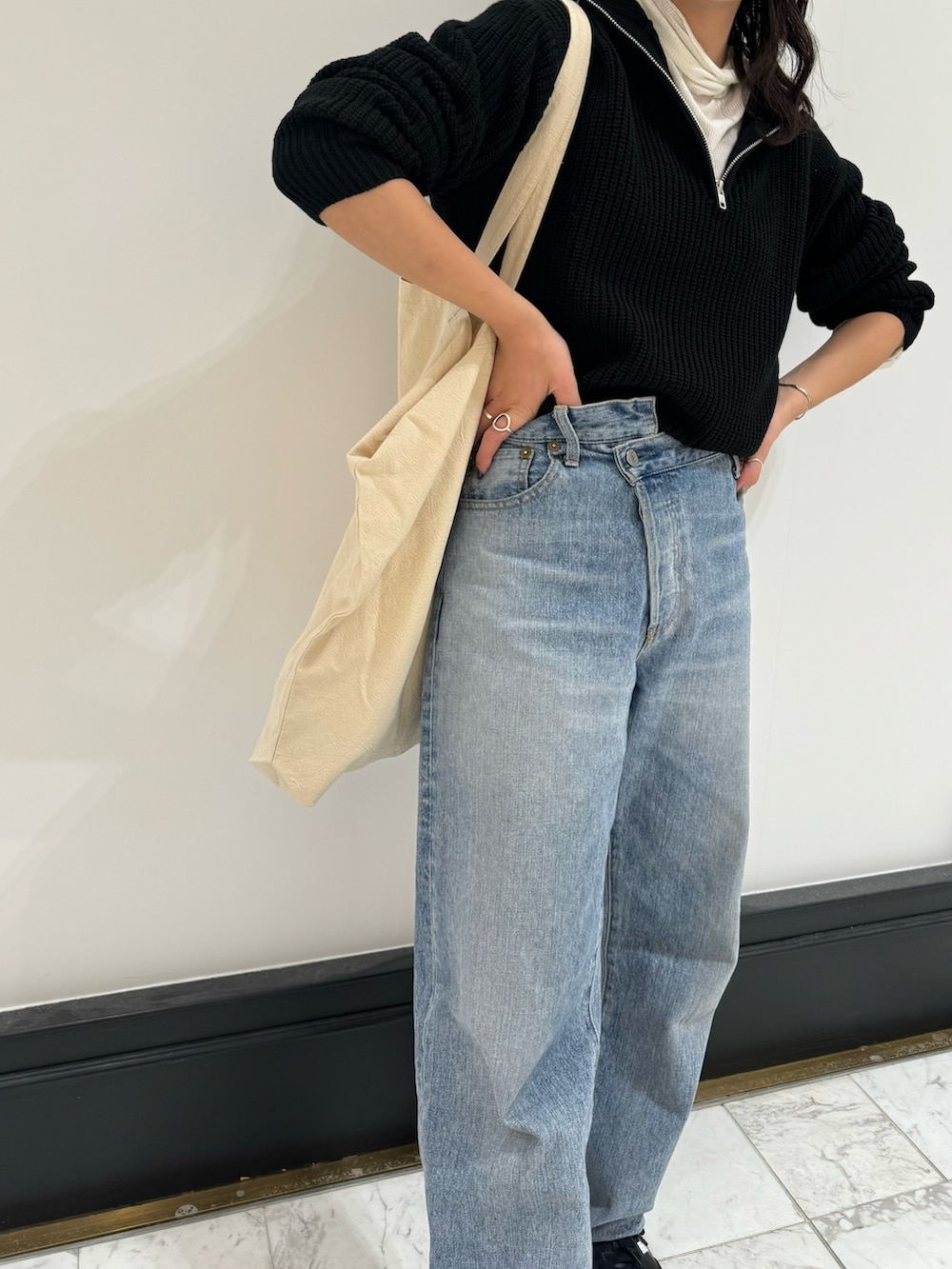 ブルー系のデニムパンツ、ホワイト系のトートバッグ、ホワイト系のTシャツ/カットソーを着用したレディースの冬コーディネートの10枚目の写真